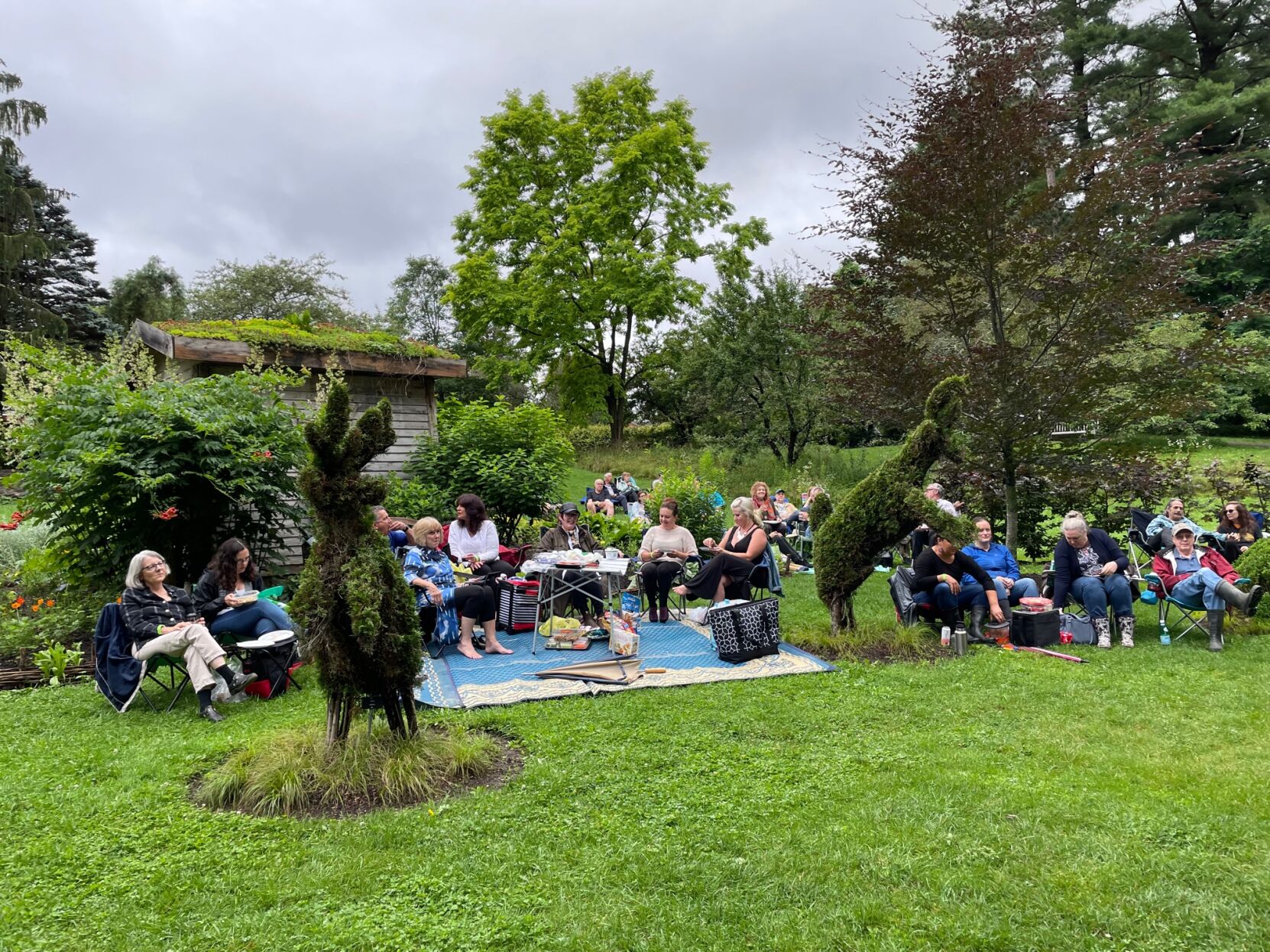 People picnic near topiaries
